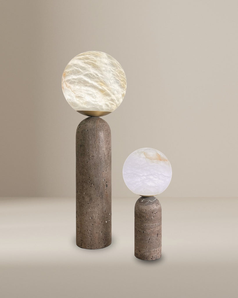 Pair of modern alabaster globe table lamps with cylindrical stone bases in beige minimalist setting