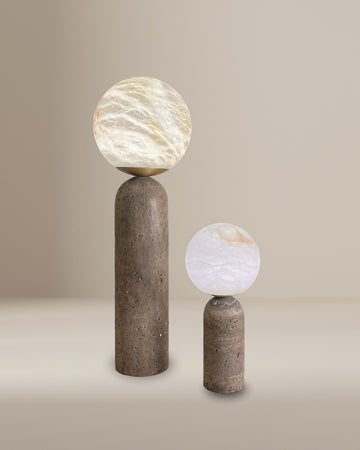 Pair of modern alabaster globe table lamps with cylindrical stone bases in beige minimalist setting