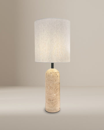 Kali Travertine Table Lamp with a minimalist cylindrical stone base and soft fabric shade, set against a neutral background for a modern, natural aesthetic.