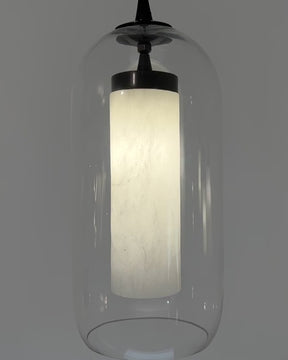 Close-up video of illuminated alabaster cylinder pendant light encased in clear dome glass shade, showcasing soft glow and natural stone texture
