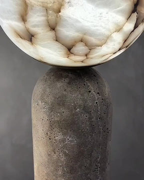 Close-up video of two Baudet table lamps with textured marble globe tops and cylindrical stone bases against a gray background